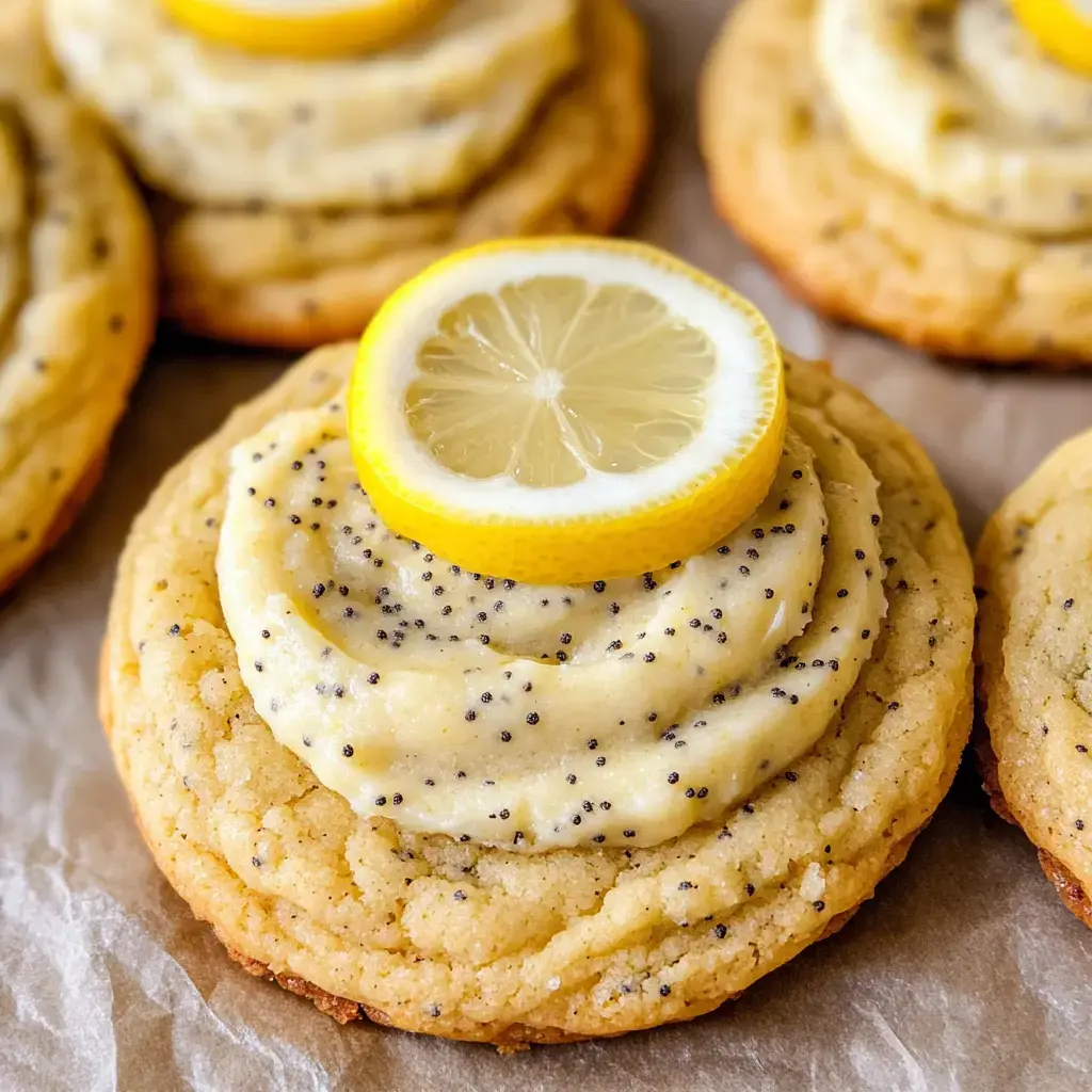 A close-up of a lemon poppy seed cookie topped with creamy frosting and a slice of lemon.