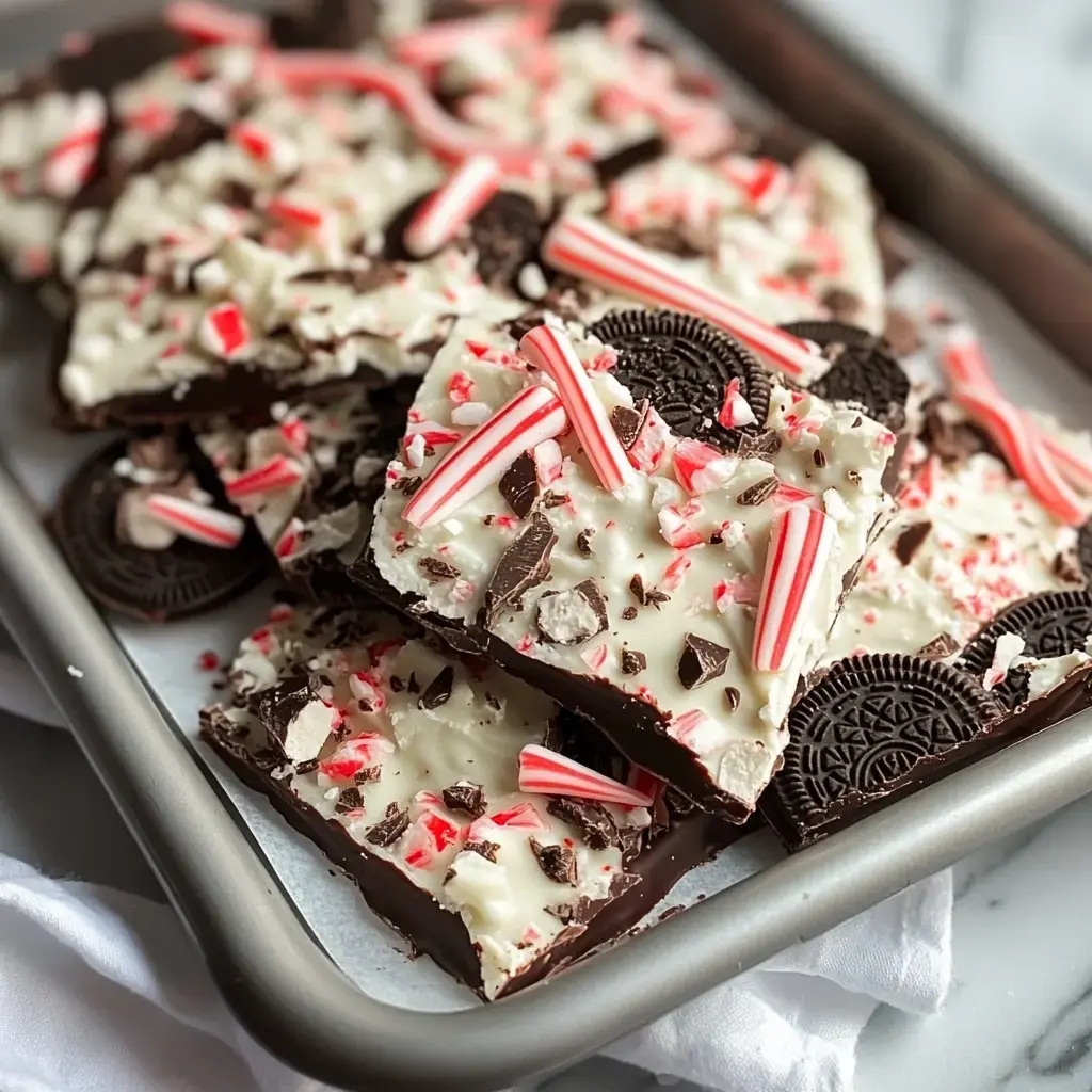 A tray of peppermint bark topped with crushed candy canes and Oreo pieces.