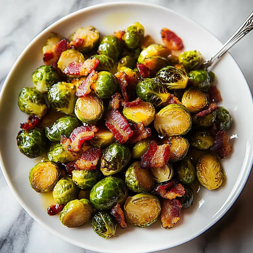 A close-up of a bowl filled with roasted Brussels sprouts mixed with crispy bacon bits.