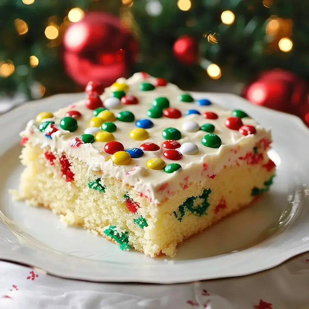 A slice of festive cake topped with colorful candy and frosting, sitting on a decorative plate with holiday decorations in the background.