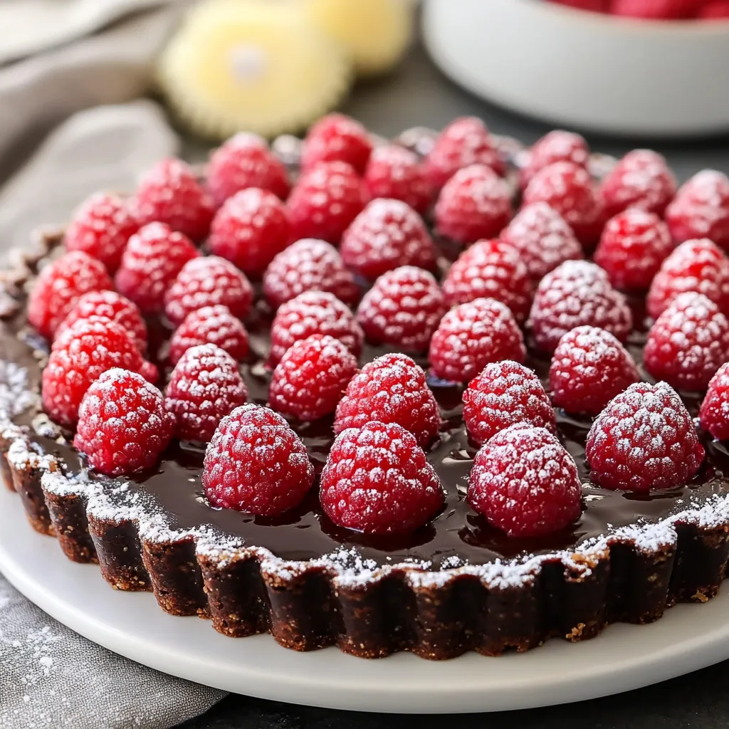 A chocolate dessert with raspberries on top.