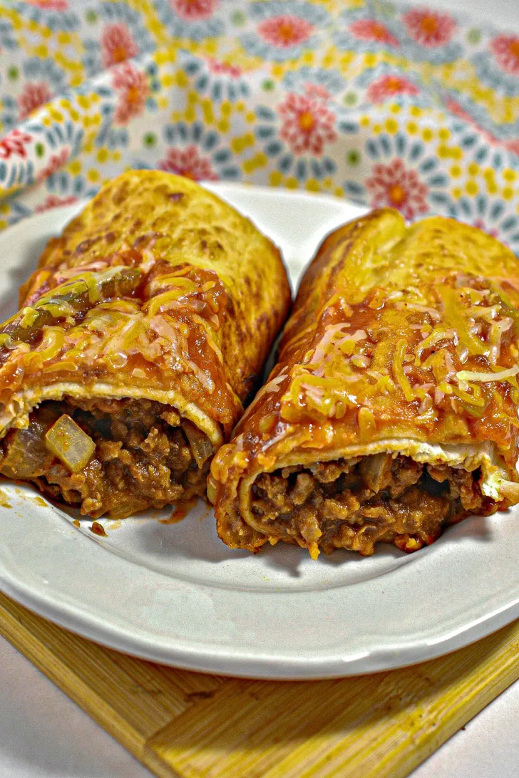 Two beef and cheese chimichangas on a plate.