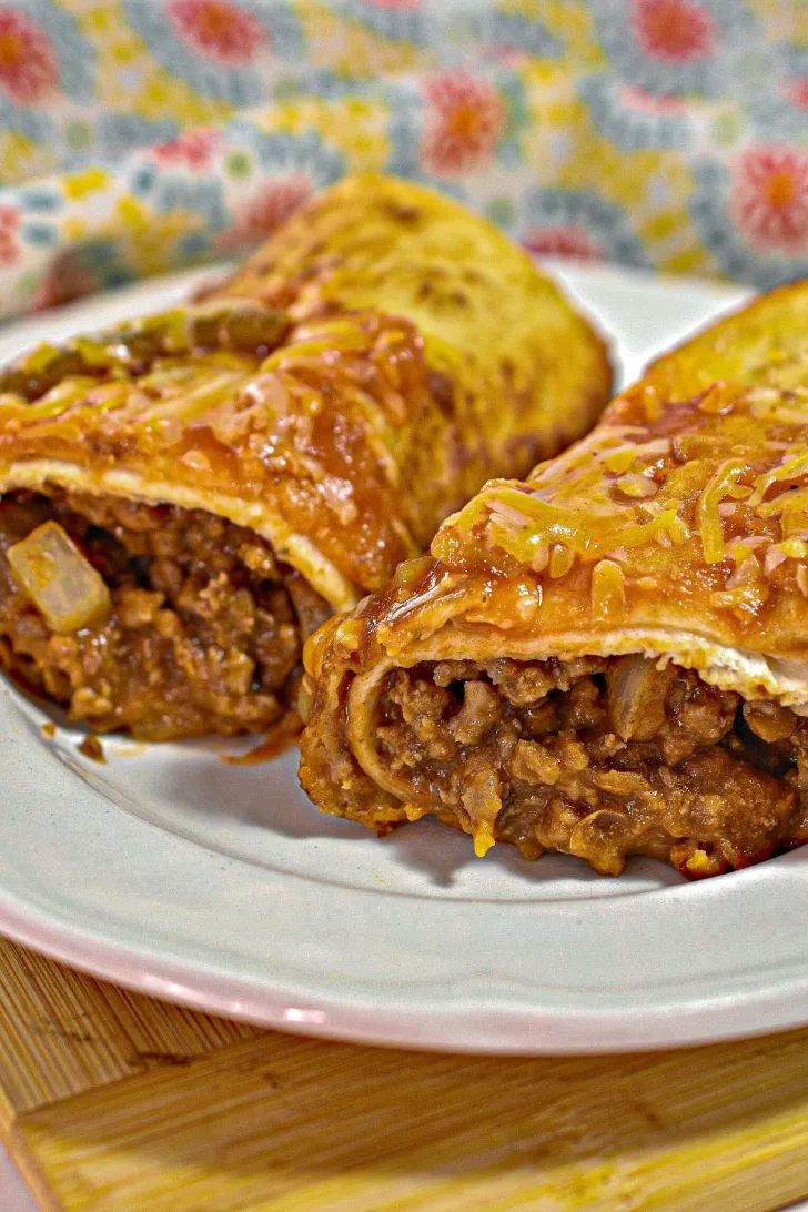 Two beef and cheese chimichangas on a plate.