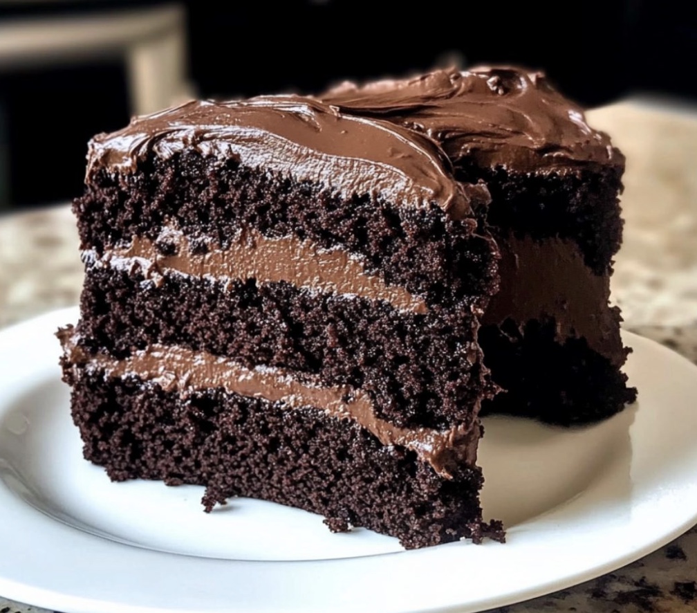 A slice of chocolate cake on a white plate.