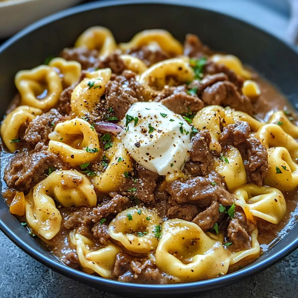 A bowl of cheesesteak, tortellini, and meat.