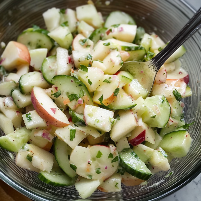 A bowl of sliced cucumbers and apples.