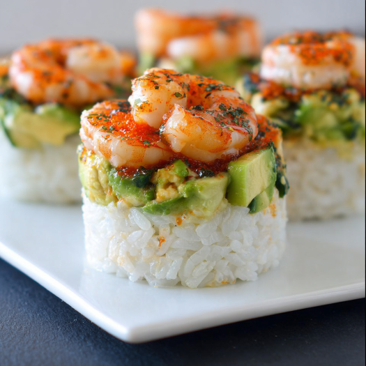 A plate of shrimp and rice with a spicy sauce.