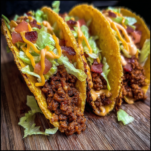 A delicious meal of chili cheese tacos with lettuce and tomatoes.