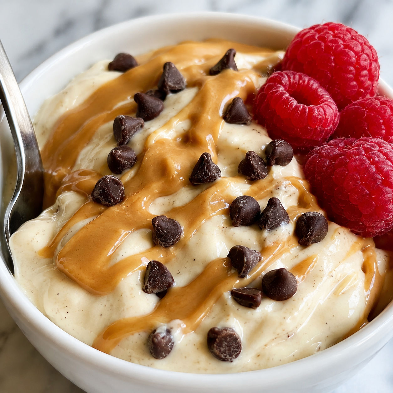 Protein yogurt pudding with peanut butter drizzle and mini chocolate chips
