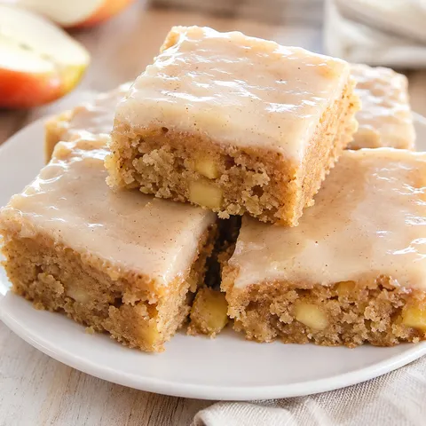 Maple glazed apple brownie squares on a white dessert plate