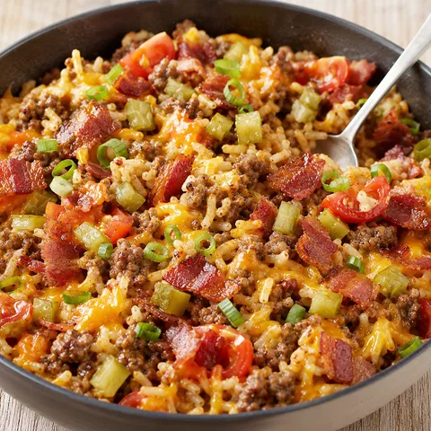 Bacon cheeseburger rice with melted cheddar, bacon, pickles, and green onion