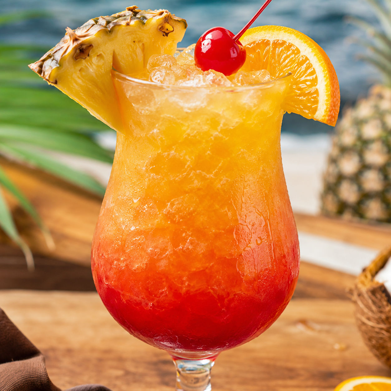 Bahama Mama cocktail with pineapple, orange, cherry, and a grenadine sunset layer