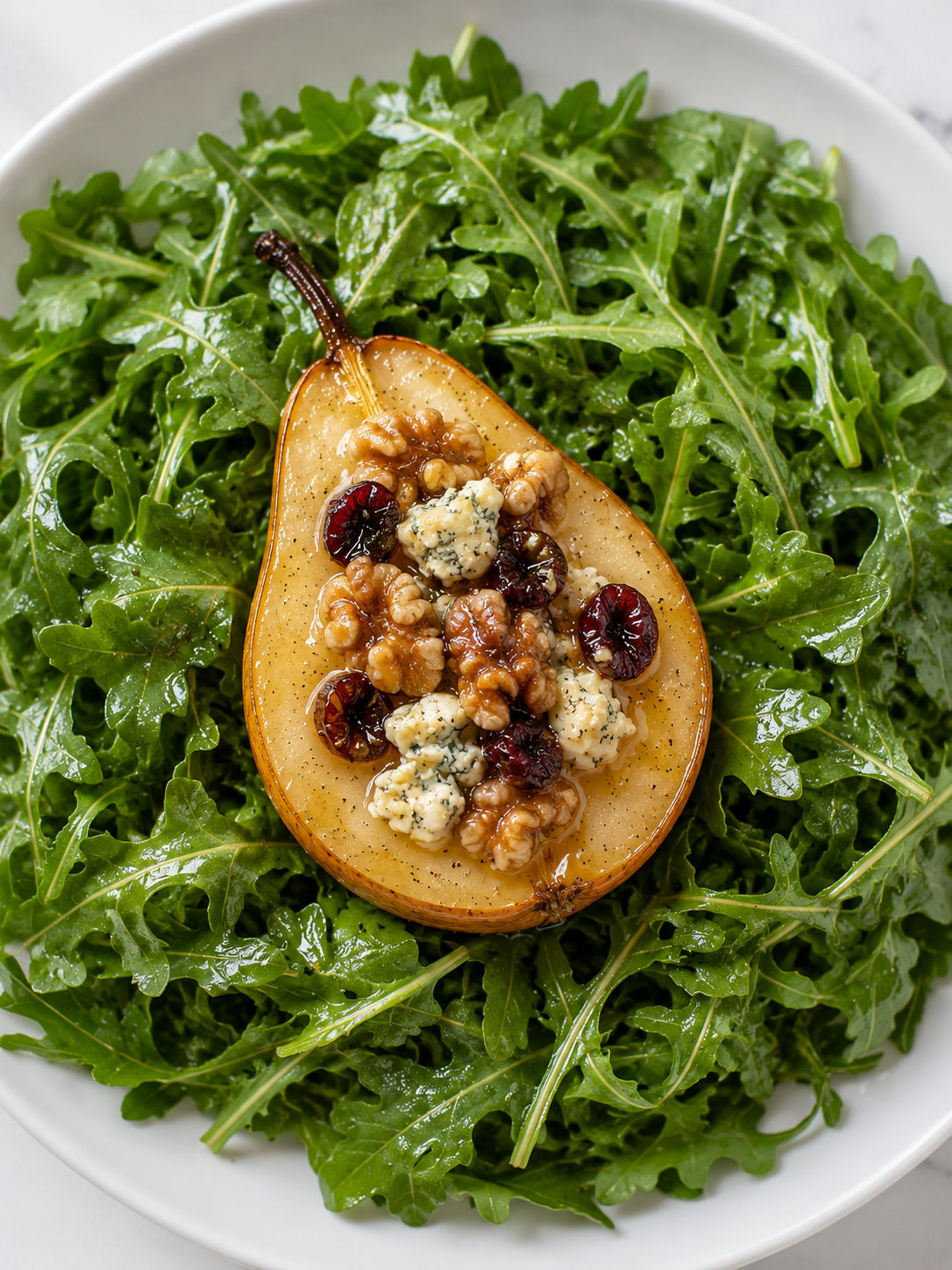 Warm roasted pear blue cheese salad with walnuts, cranberries, and arugula