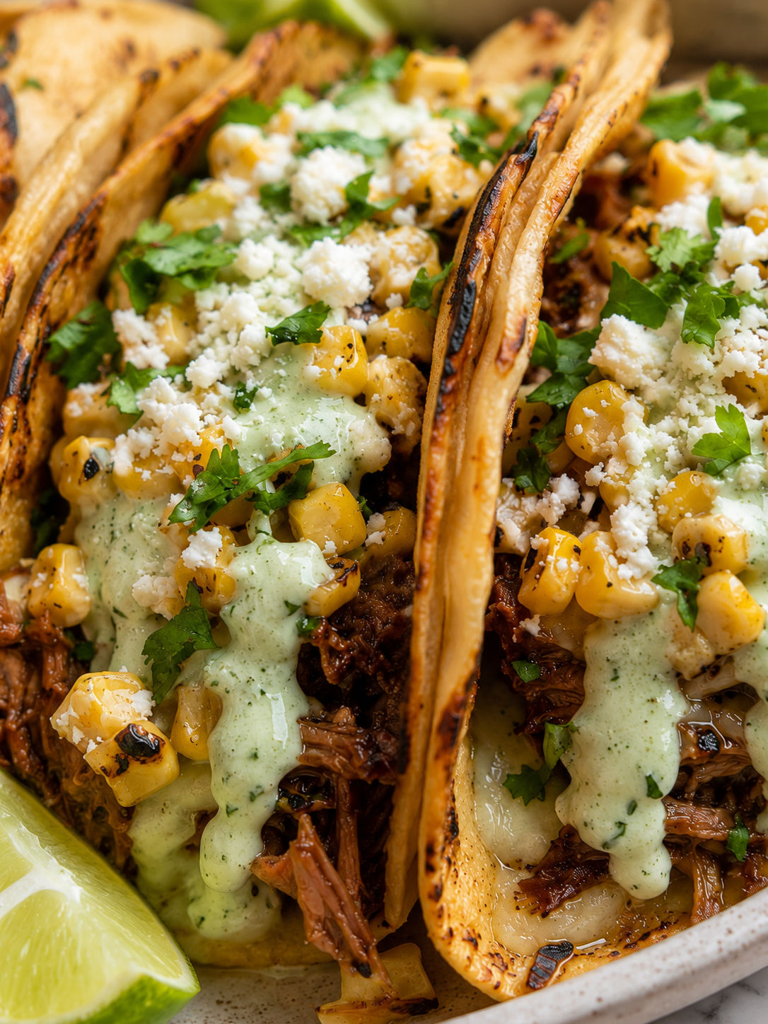 Braised Brisket Tacos With Street Corn and Jalapeño Lime Ranch, plated and served
