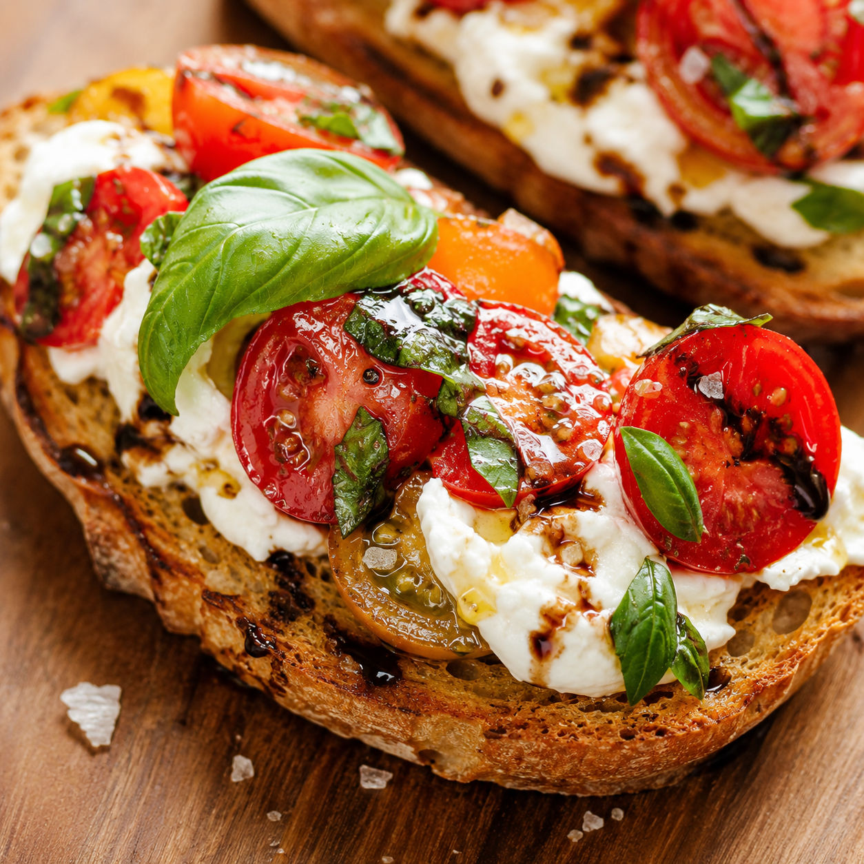 Burrata bruschetta with tomatoes, basil, and balsamic glaze on toast