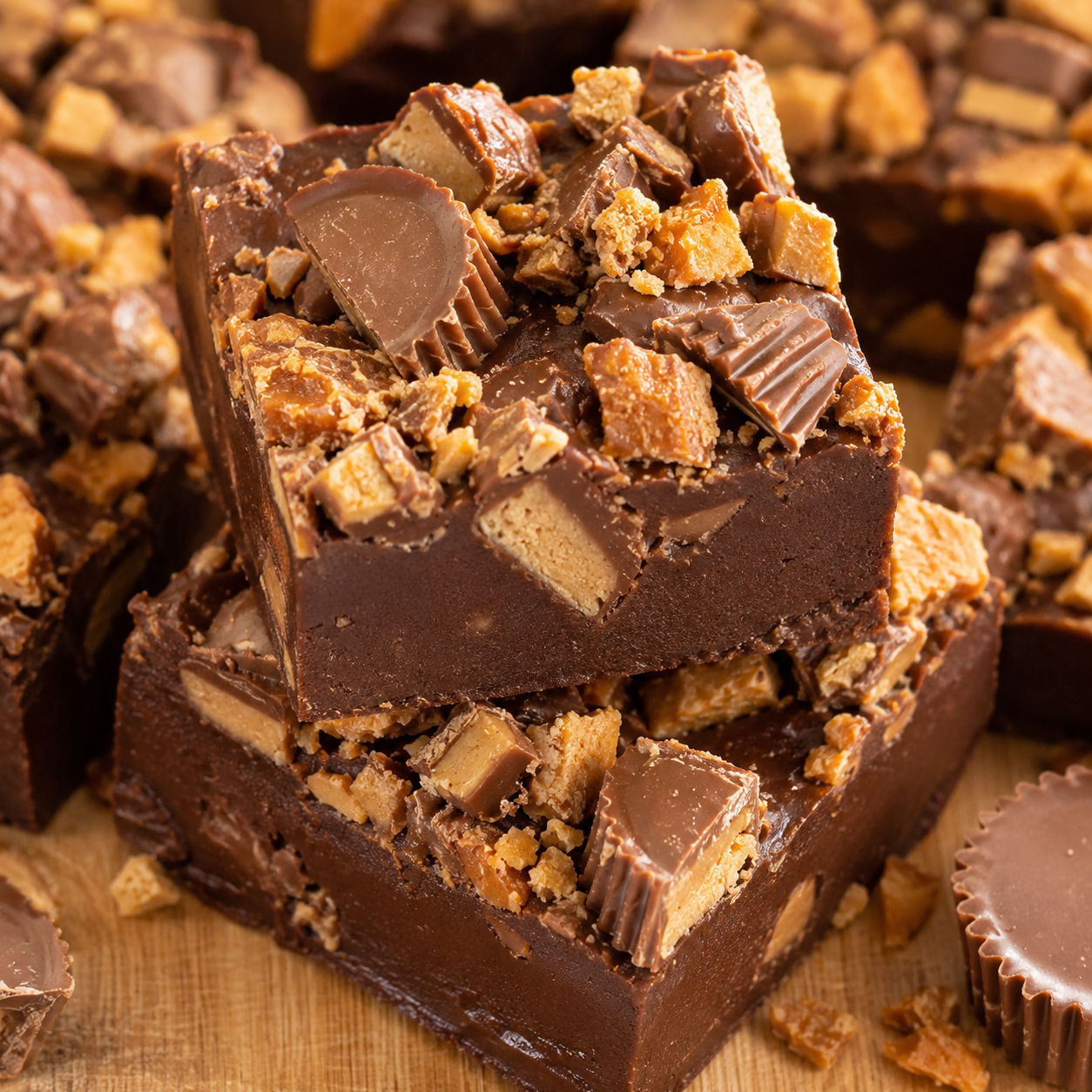 Butterfinger Reese's fudge squares topped with candy pieces on a wooden board