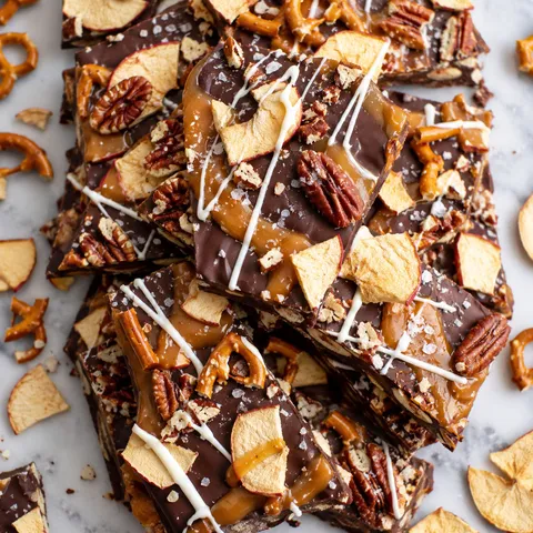 Caramel apple bark with pretzels, apple chips, pecans, and white chocolate drizzle