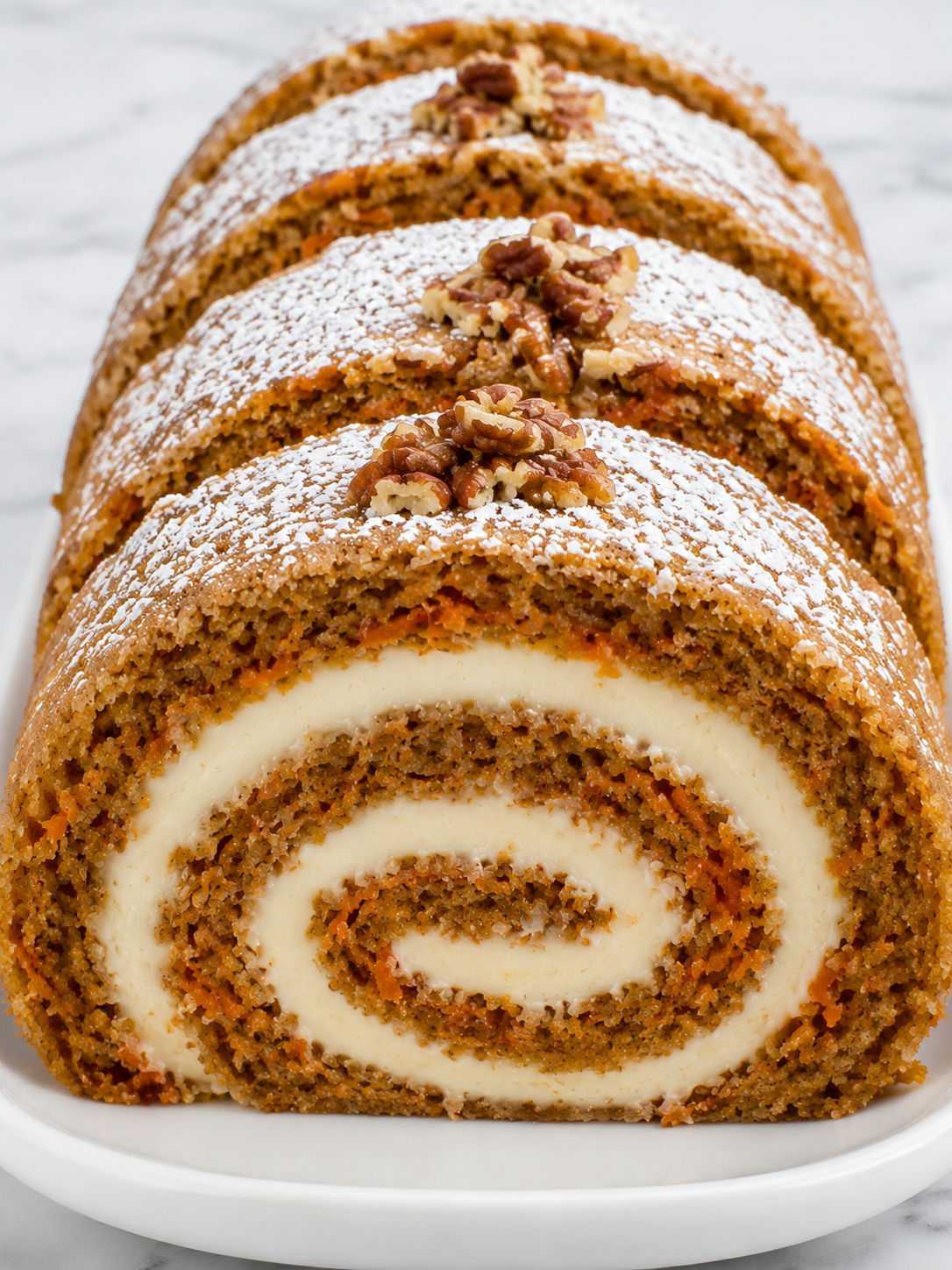 Carrot cake roll slices with cream cheese swirl and powdered sugar