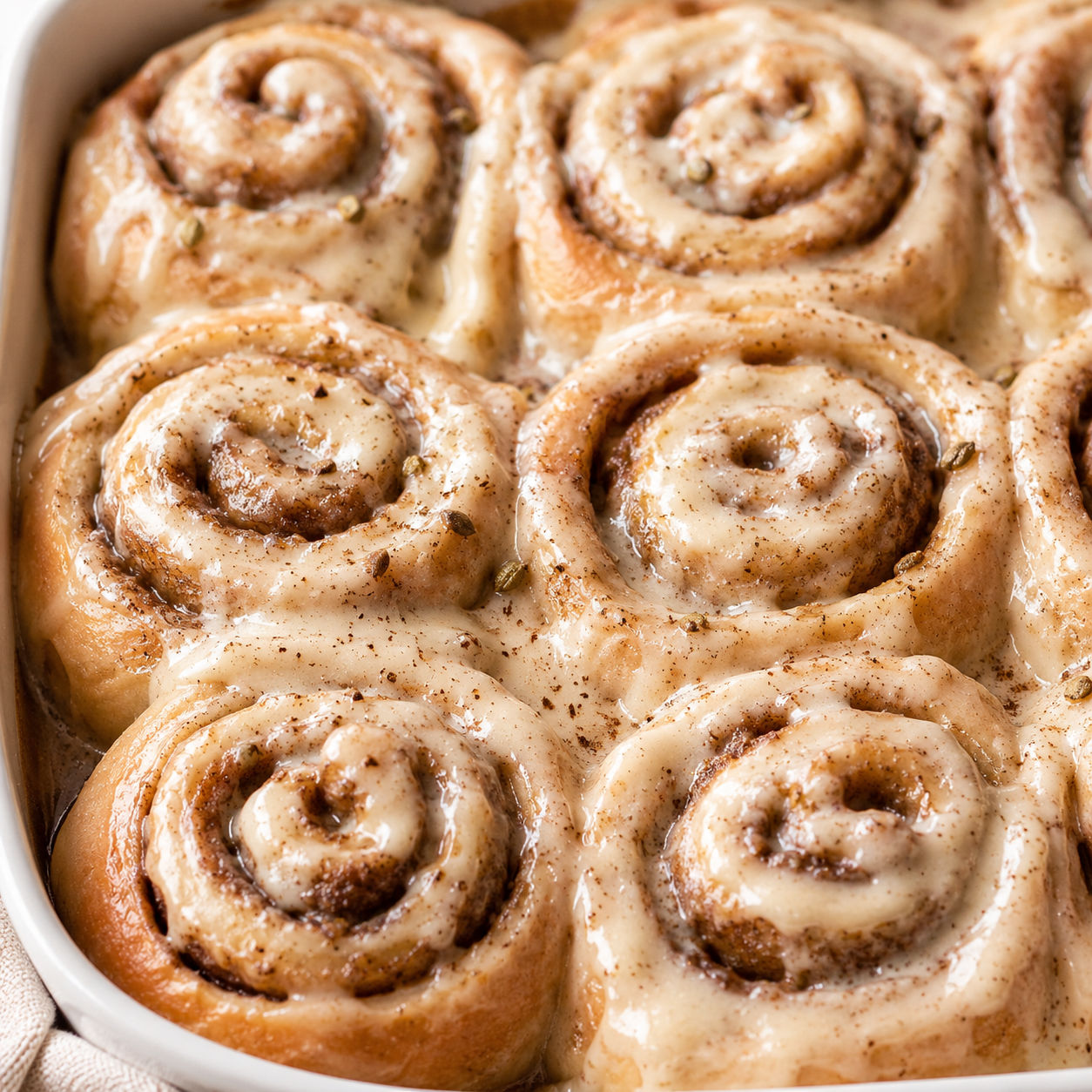 Chai cinnamon rolls with cream cheese icing in a baking dish