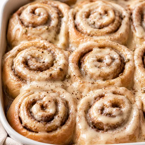 Chai cinnamon rolls with cream cheese icing in a baking dish