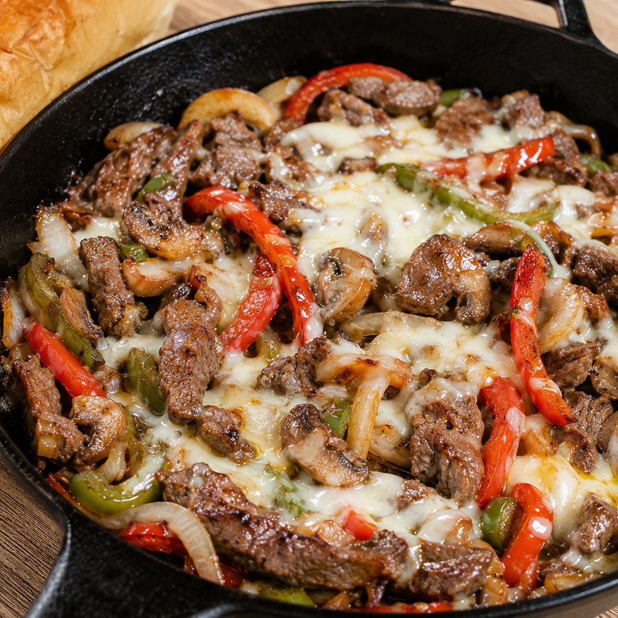 Cheese steak skillet with beef, peppers, mushrooms, and melted provolone