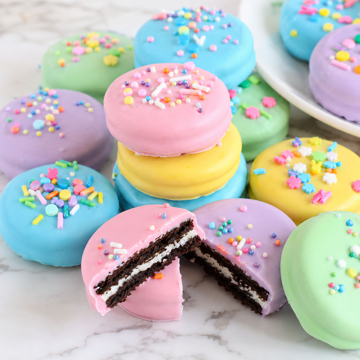Pastel chocolate covered Easter Oreos with sprinkles on a white plate