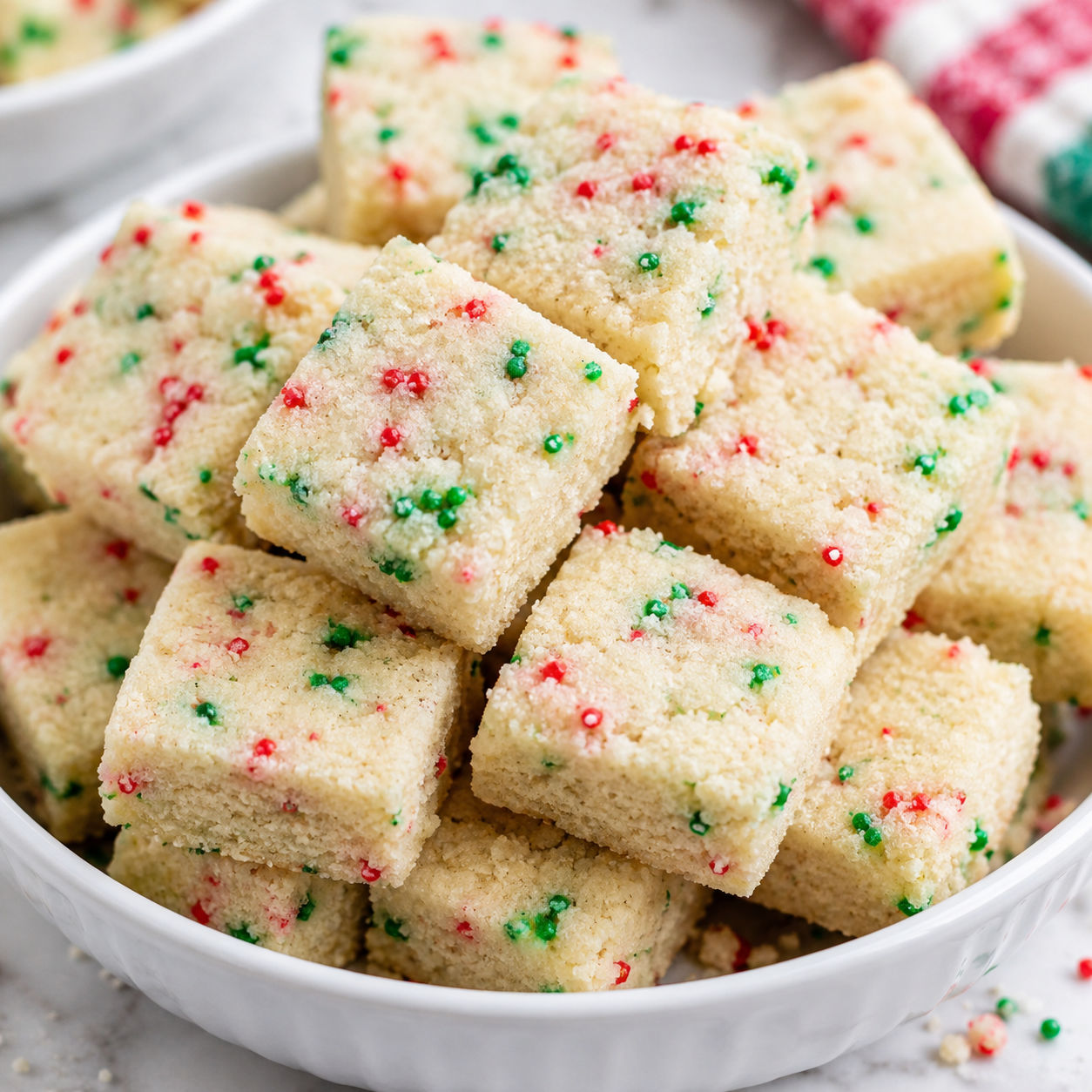 Christmas shortbread bites with red and green sprinkles in a white bowl