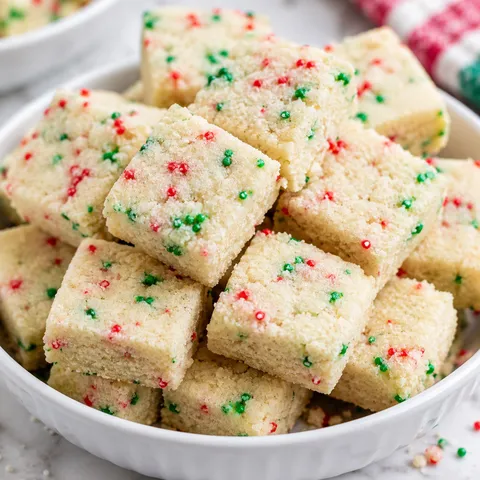 Christmas shortbread bites with red and green sprinkles in a white bowl