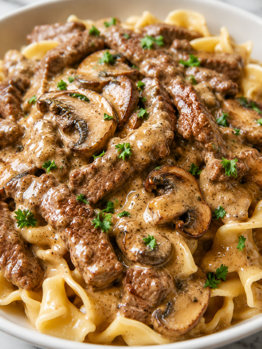 Creamy Classic Beef Stroganoff over egg noodles with parsley