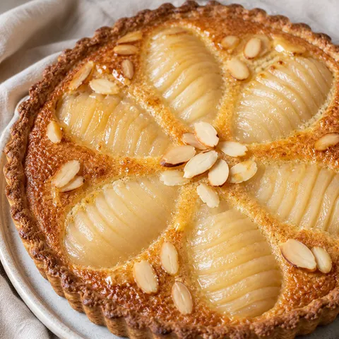 French pear frangipane tart with fanned pears and glossy almond filling