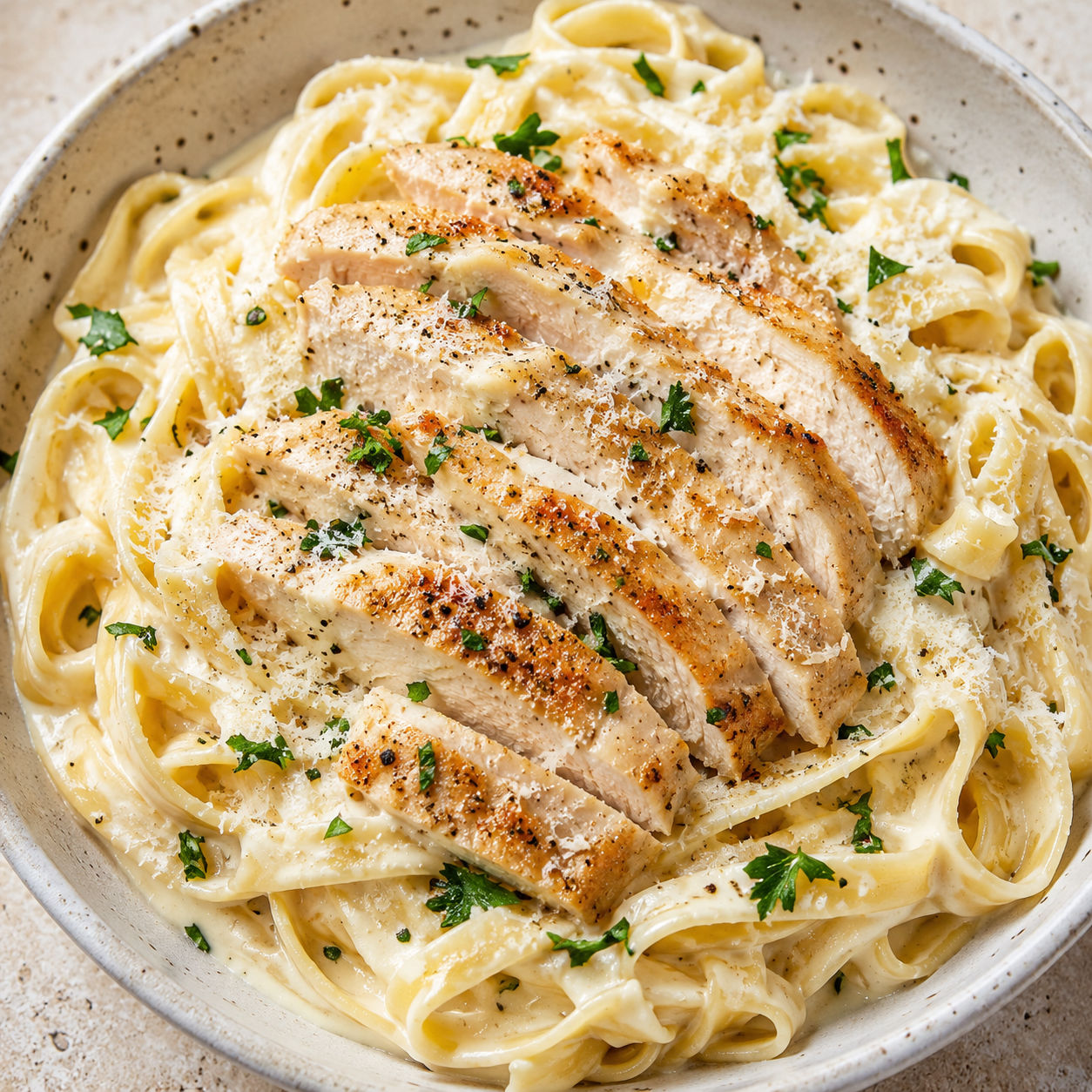 Chicken Alfredo fettuccine with creamy Parmesan sauce and parsley