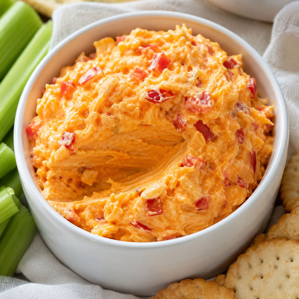 Southern pimento cheese in a white crock with crackers and celery