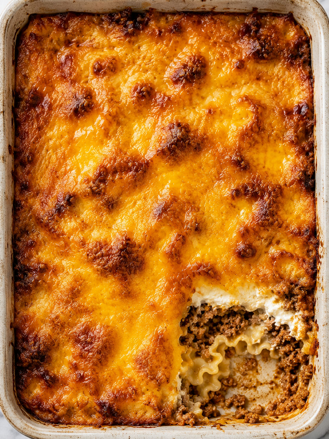 Crazy Good Casserole with golden cheddar crust and creamy beef layers seen from above