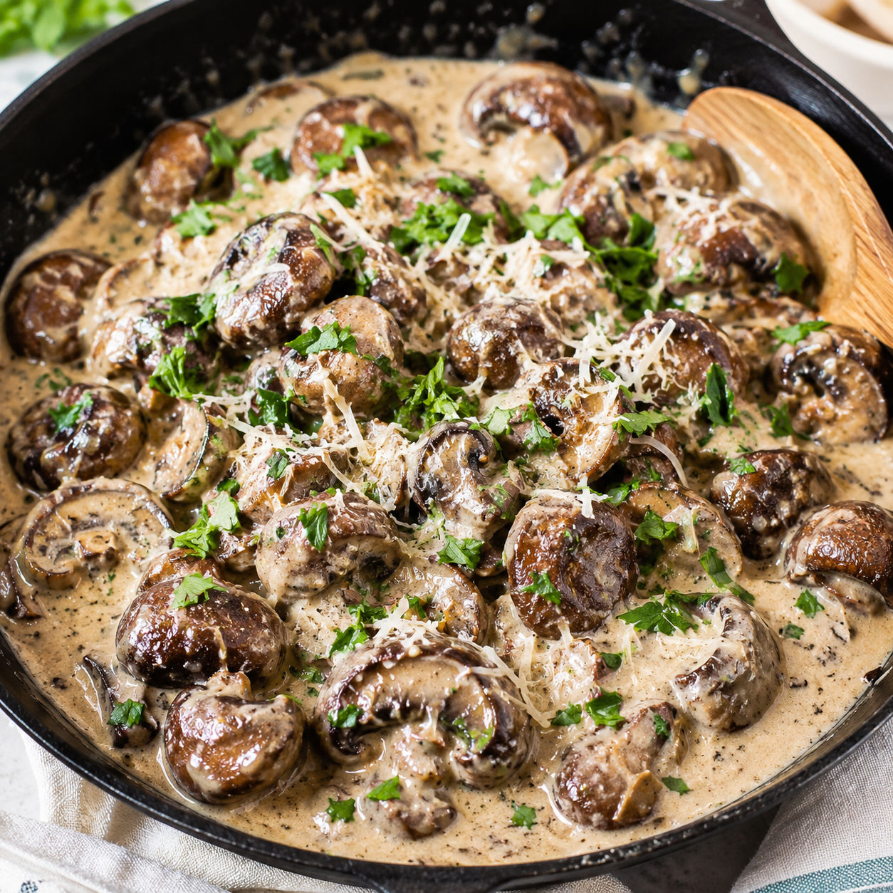 Creamy garlic parmesan mushrooms in a skillet with parsley