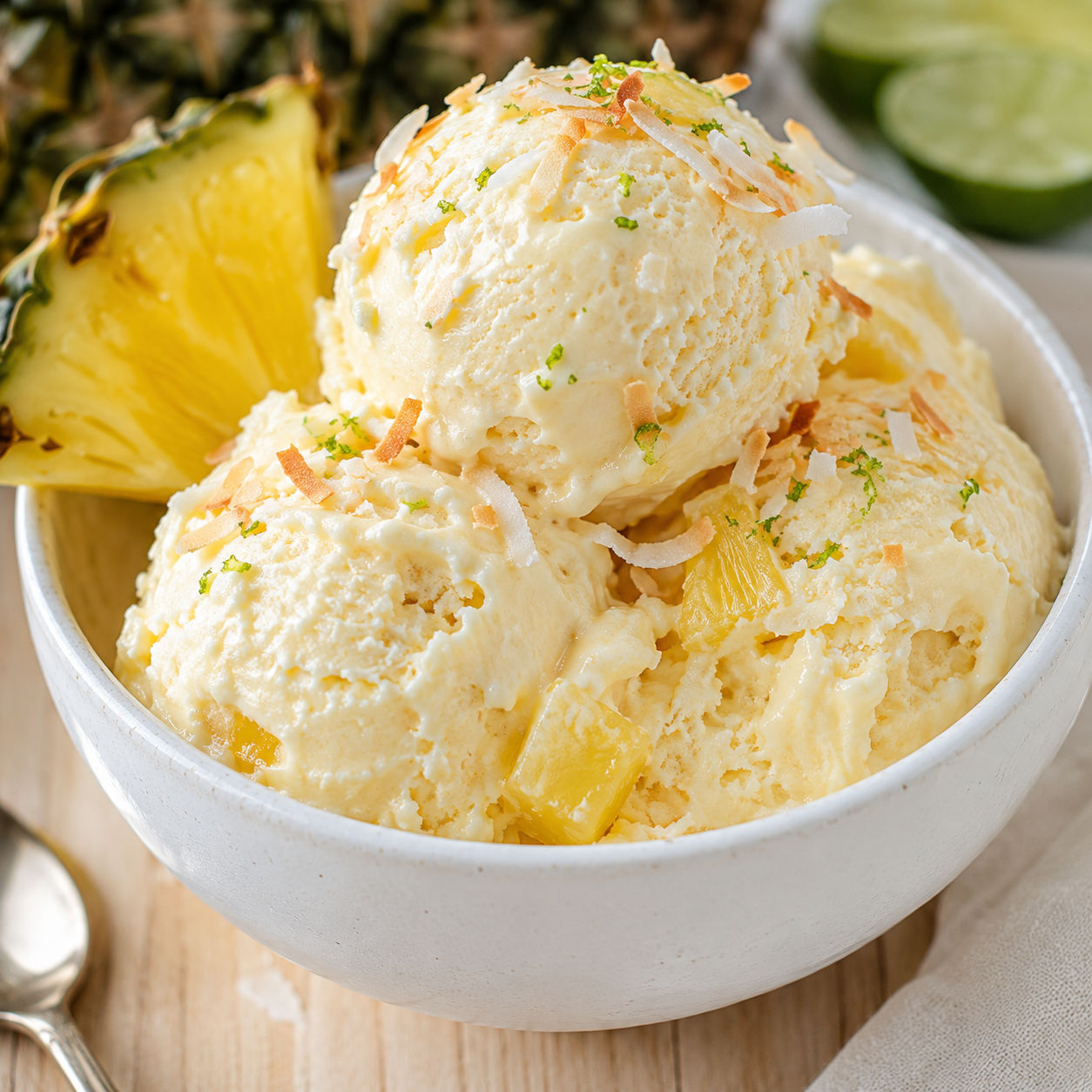 Creamy pineapple ice cream with coconut and lime zest in a white bowl