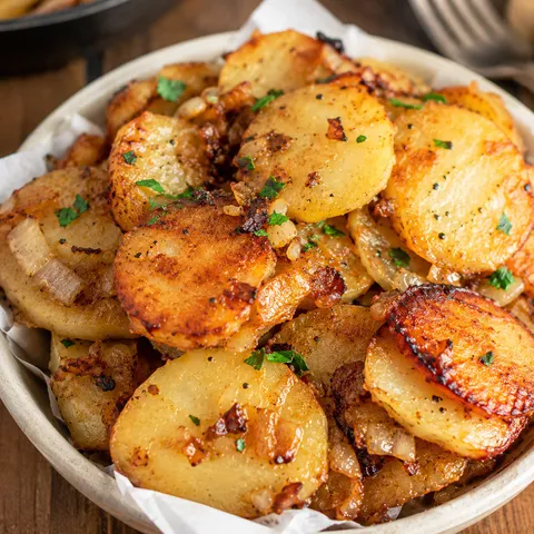 Southern fried potatoes with browned onions in a shallow bowl