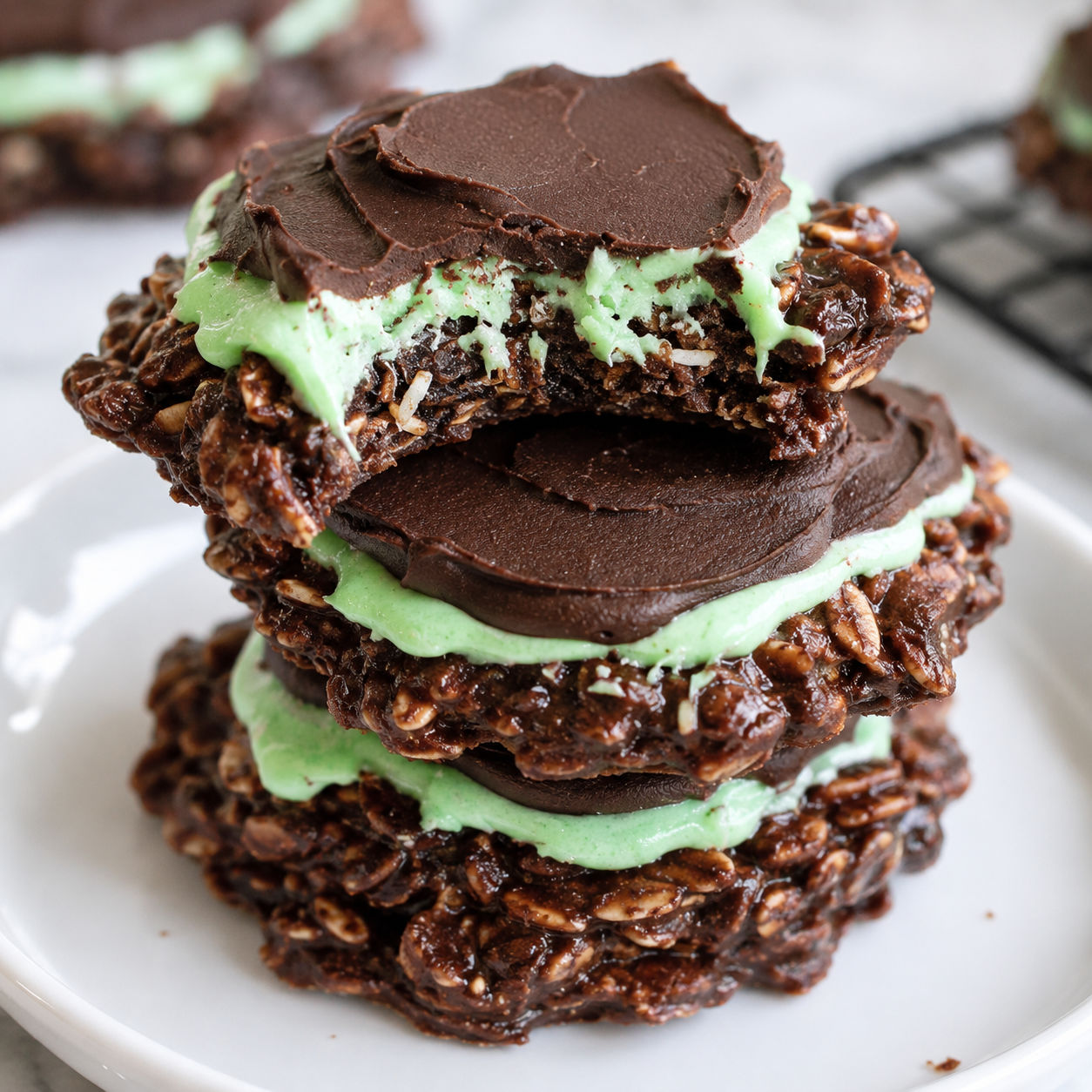 Fudgy mint chocolate no-bake cookies with green frosting and glossy chocolate