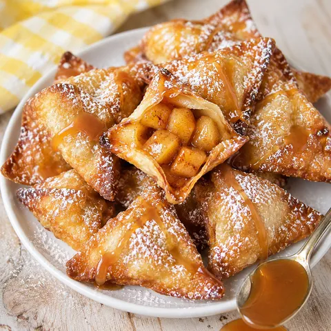 Caramel apple wontons with powdered sugar and caramel drizzle