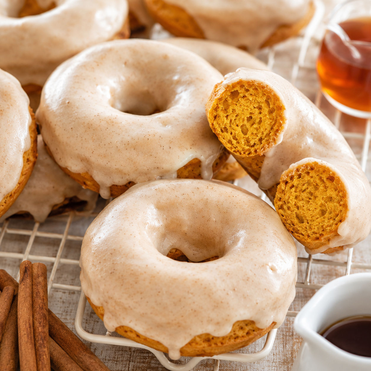 Baked pumpkin donuts with glossy maple glaze on a wire cooling rack