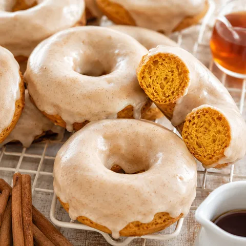 Baked pumpkin donuts with glossy maple glaze on a wire cooling rack