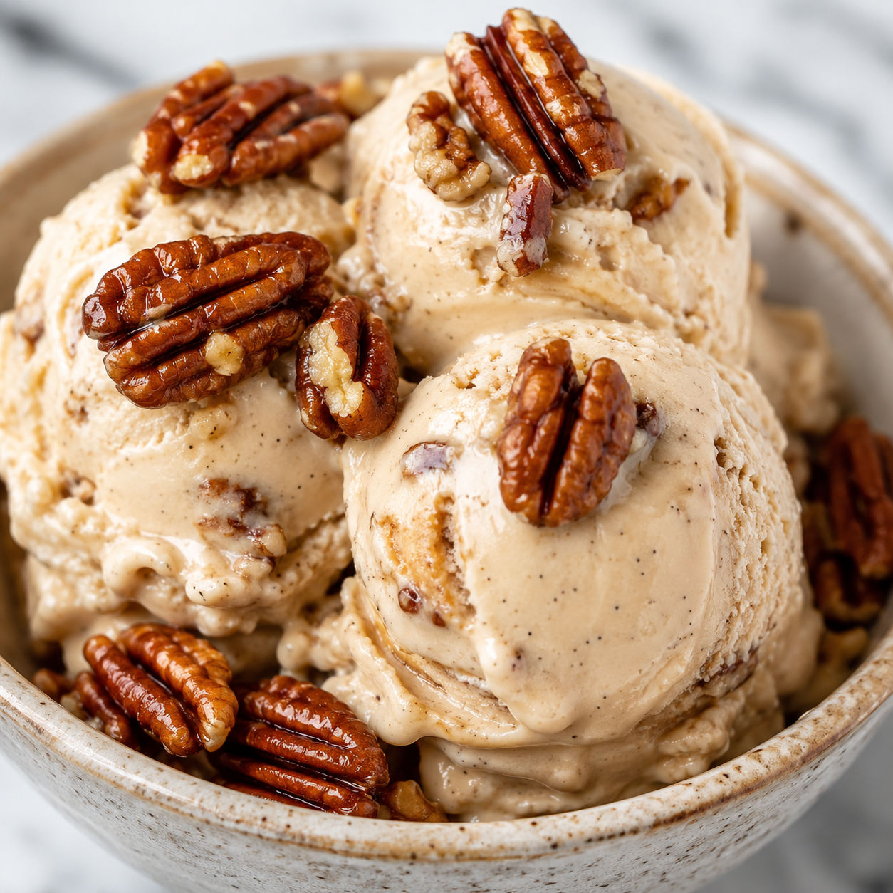 Butter pecan ice cream with toasted pecans in a ceramic bowl