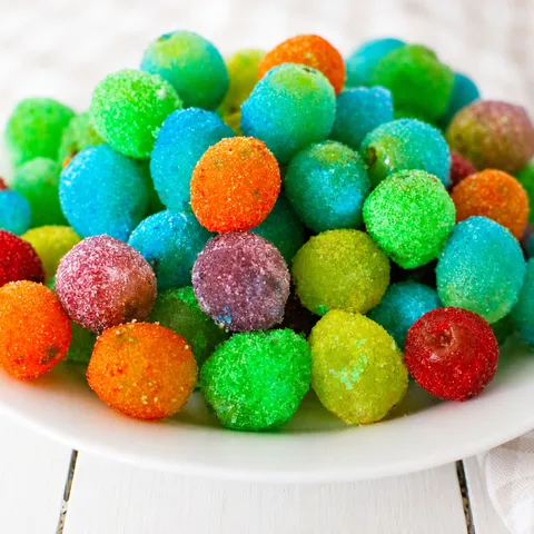 Colorful frozen Jello grapes on a white plate