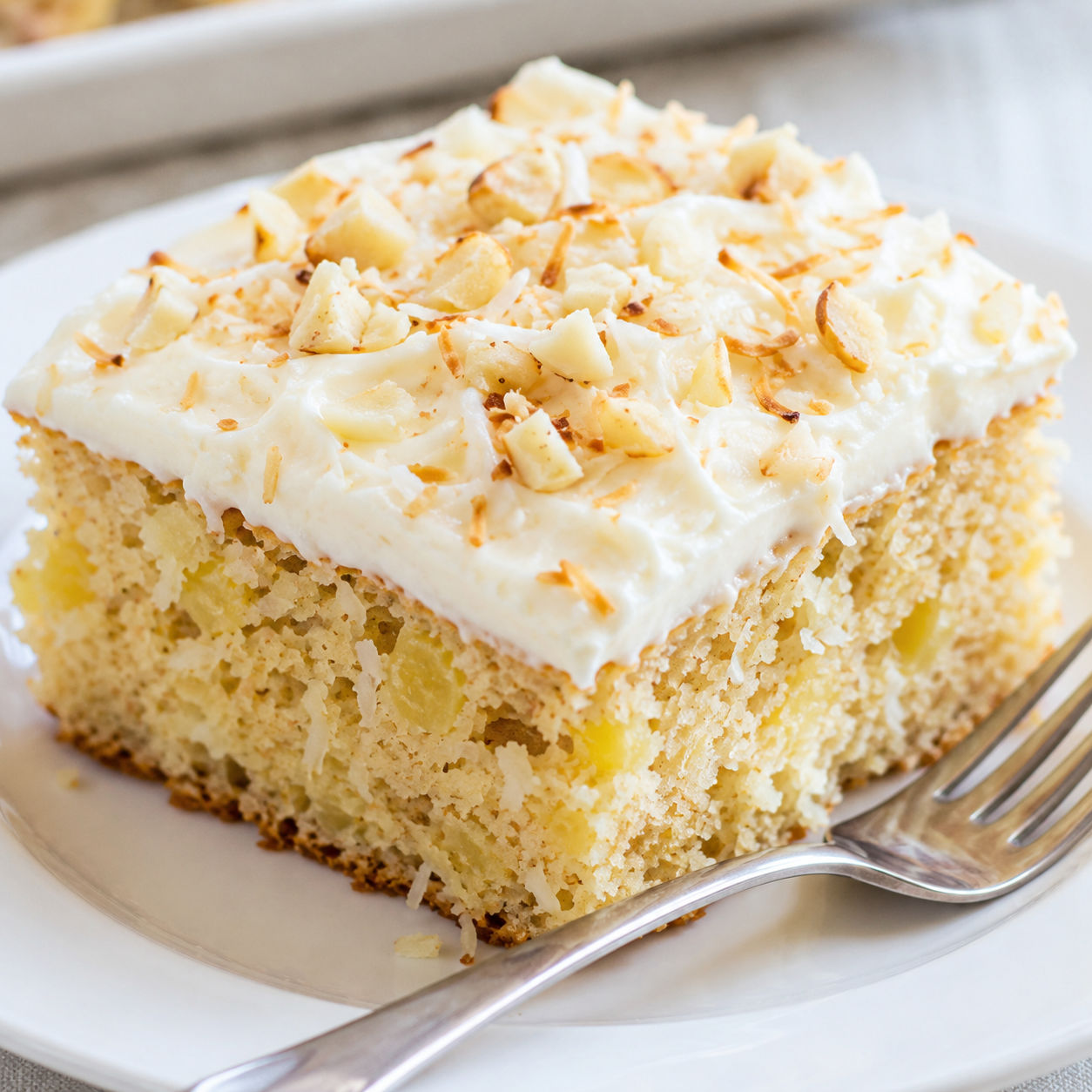 Hawaiian pineapple cake slice with cream cheese frosting and toasted coconut