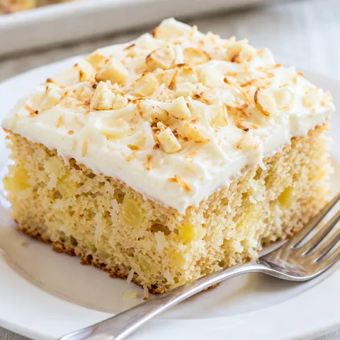 Hawaiian pineapple cake slice with cream cheese frosting and toasted coconut