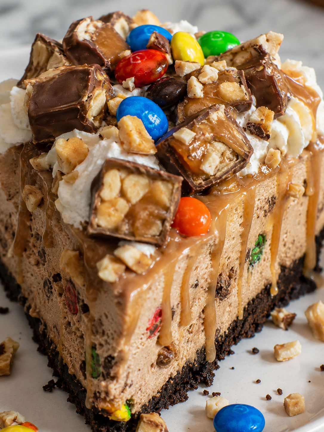 Delicious No-Bake M&M Snickers Cheesecake, plated and served
