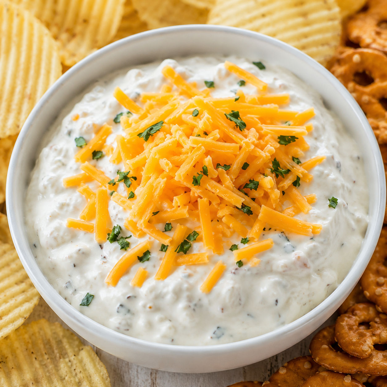 Creamy cheddar ranch crack dip with chips and cheddar topping