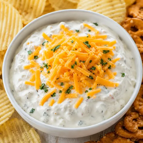 Creamy cheddar ranch crack dip with chips and cheddar topping