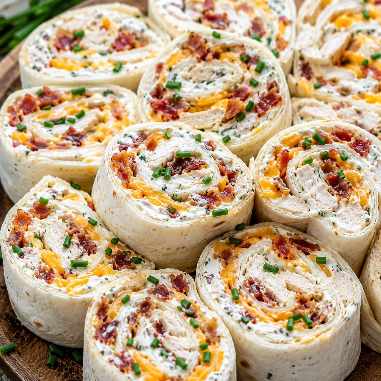 Platter of chicken bacon ranch tortilla pinwheels with chive garnish