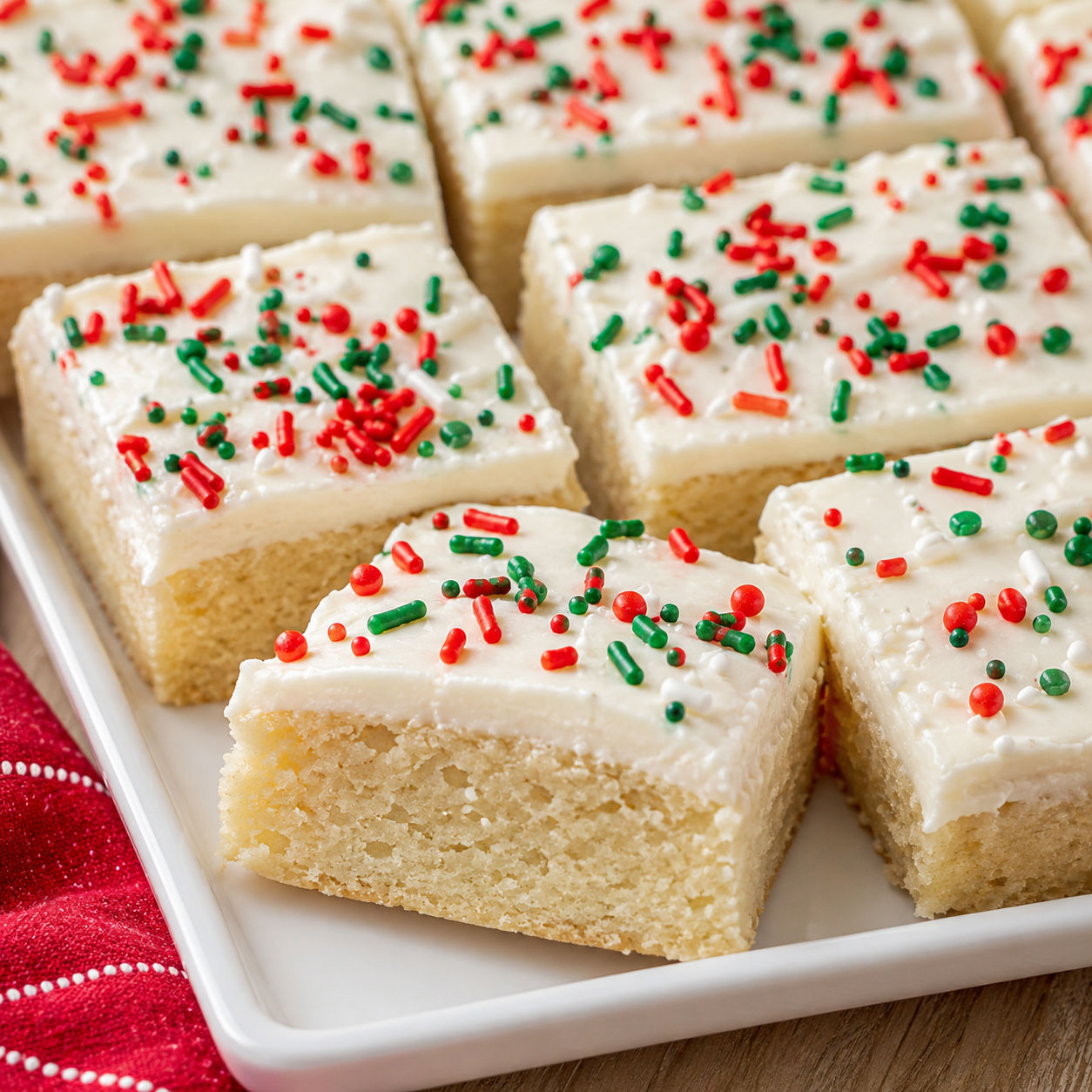 Christmas sugar cookie bars with white frosting and red and green sprinkles