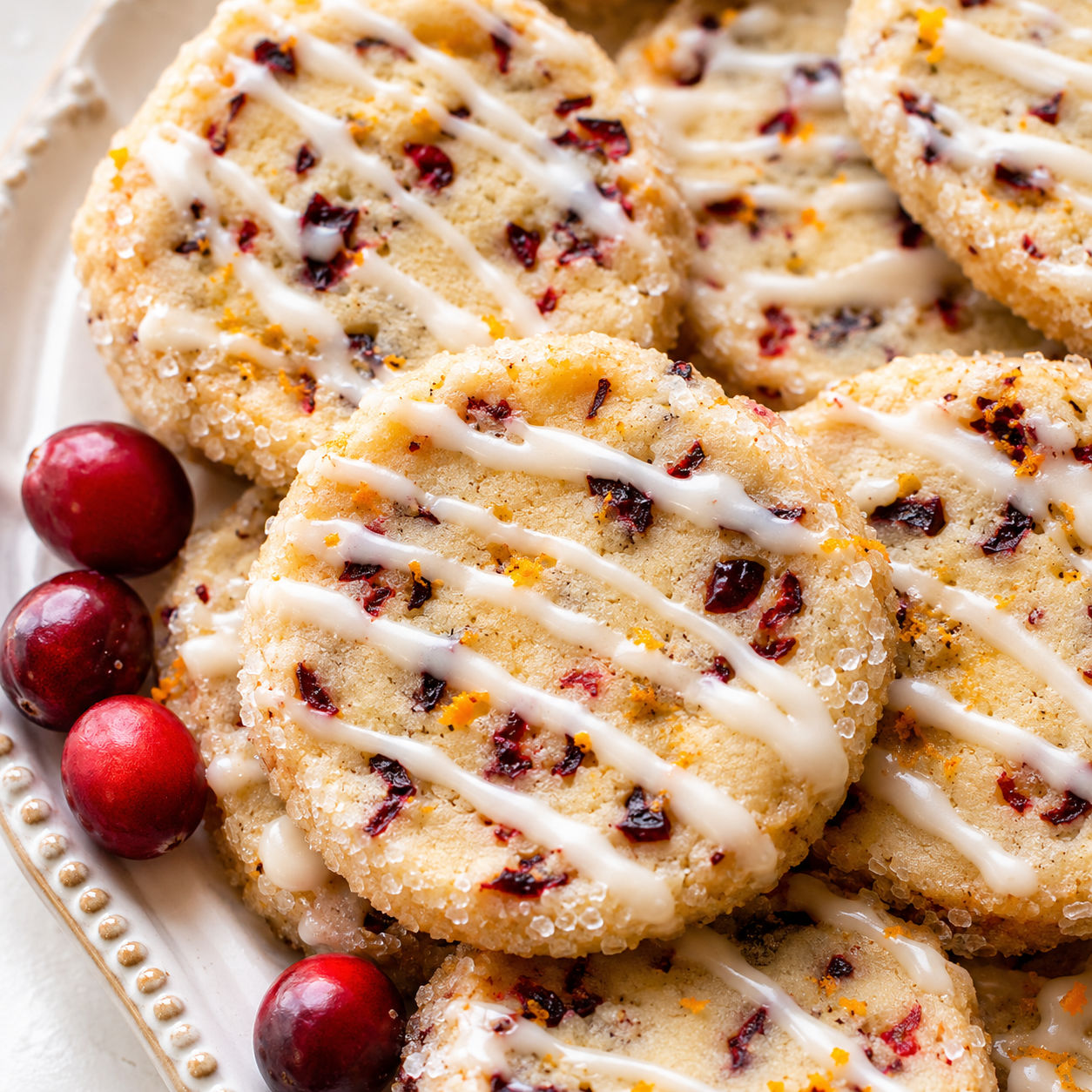 Cranberry orange icebox cookies with sugar edges and orange glaze